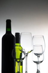 Set of wine bottles and glasses on grey background