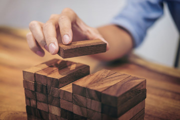 Alternative risk concept, plan and strategy in business, Risk To Make Business Growth Concept With Wooden Blocks, hand of man has piling up a wooden block