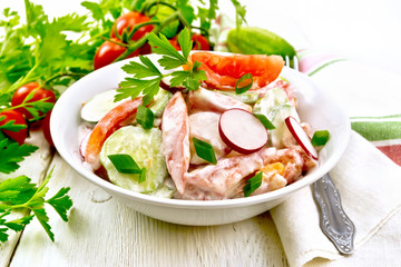 Salad from fresh vegetables and greens in plate on board