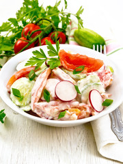 Salad from fresh vegetables in plate on board