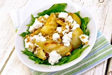 Salad from pear and spinach in dish on kitchen towel