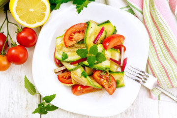 Salad with zucchini and tomato in plate on board top