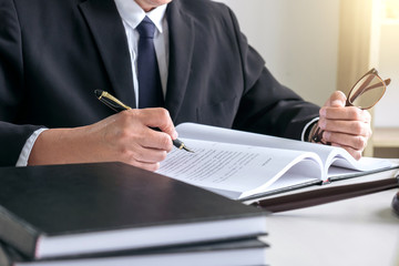 Male lawyer or judge working with Law books, gavel, report the case on table in modern office, Law and justice concept