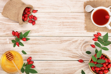 tea with rose hips and honey on white wooden background with copy space for your text. Top view