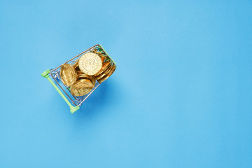 Gold Bitcoin placed in a small shopping cart. Digital currency concepts can be used to make online purchases.