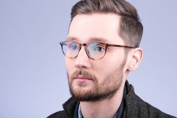 Stylish men's glasses. Closeup portrait of young man with beard and mustache