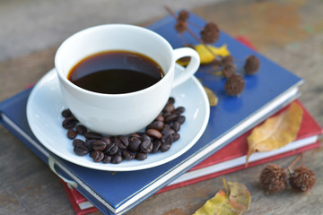 Black coffee in white cup with beans.
