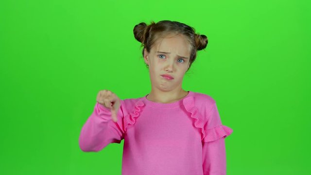 Child is showing a thumbs down. Green screen