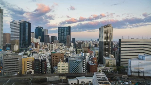 Shinjuku sunrise skyline with business skyscrapers and metro system in Tokyo, Japan. High angle time lapse with sky and subway trains