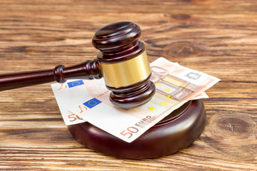 Gavel with euro bills on the table.