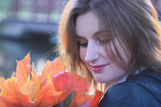 Young romantic beautiful Russian girl Maria in the autumn park dreams of love