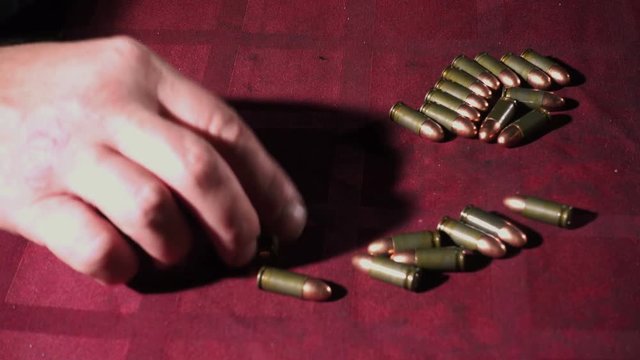 Man hands count handgun cartridges close up. 4K UHD
