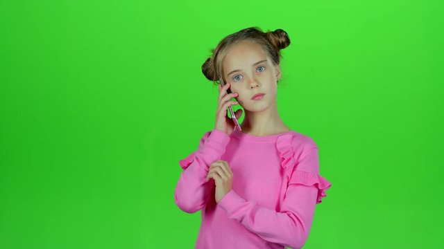 Baby is talking on the phone with her mom. Green screen