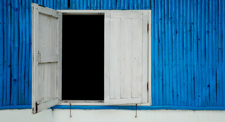 Fototapeta na wymiar blue colored wood wall with old white wooden window