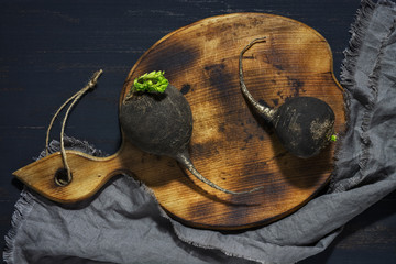 Black radish on wooden board