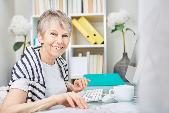 Zufriedene Seniorin arbeitet im B&uuml;ro