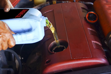 Car mechanic replacing and pouring fresh oil into engine at maintenance repair service station, closeup
