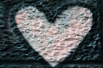 Rosarotes Herz auf einer Mauer