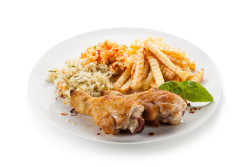 Grilled drumsticks with french fries and vegetables on white background
