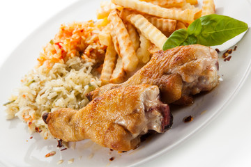 Grilled drumsticks with french fries and vegetables on white background