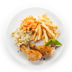 Grilled drumsticks with french fries and vegetables on white background