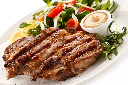 Grilled steak with vegetables on white background