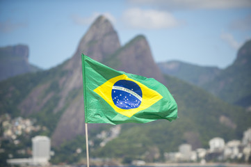 Brazil flag flying in the breeze in front of Two Brothers Mountain on Ipanema Beach in Rio de Janeiro.