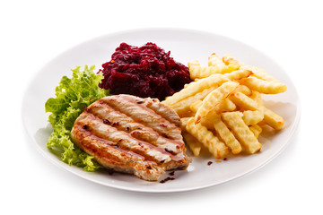 Grilled steak, French fries and vegetables on white background