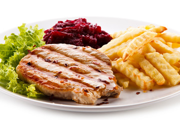 Grilled steak, French fries and vegetables on white background
