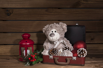 Decoración navidad con osito en maleta y farol rojo.