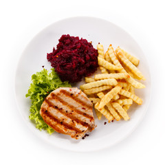 Grilled steak, French fries and vegetables on white background
