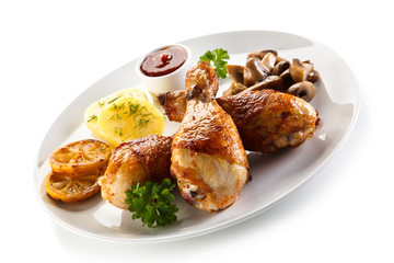 Grilled chicken drumsticks with vegetables on white background