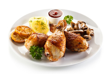 Grilled chicken drumsticks with vegetables on white background