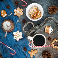 Gingerbread, candy cane and coffee cup on dark background. Christmas or New year composition. Flat lay. Top view