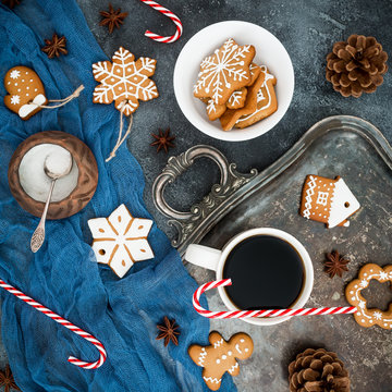 Gingerbread, candy cane and coffee cup on dark background. Christmas or New year composition. Flat lay. Top view © artifirsov