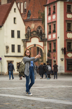 Woman traveler take selfie on a square of European city