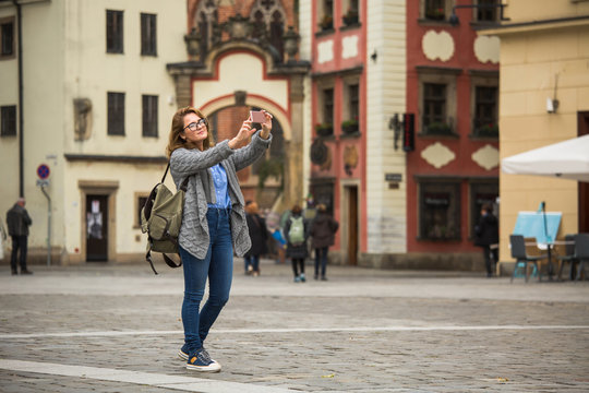 Woman traveler take selfie on a square of European city