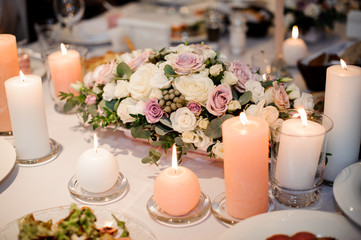 Beautiful flower composition and candles decorating a festive table
