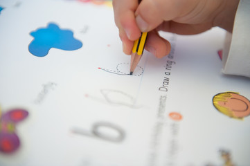 3-year-old child is learning to write by tracing alphabet letters - letter b