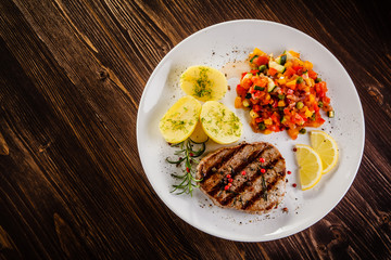 Grilled steak, boiled potatoes and vegetable salad