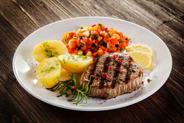 Grilled steak, boiled potatoes and vegetable salad