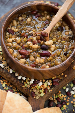 Close-up of a wooden bowl with thick bean soup, selective focus, vertical shot