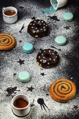 donuts with chocolate and macaroons on a dark background