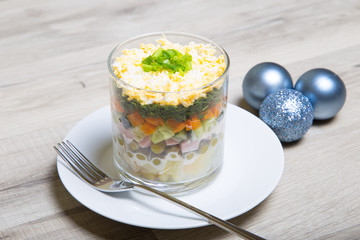 Traditional Russian salad Olivier with sausage in a glass. Selective focus, close - up.