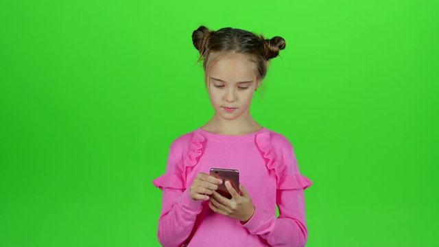 Baby is talking on the phone with her mom. Green screen. Slow motion