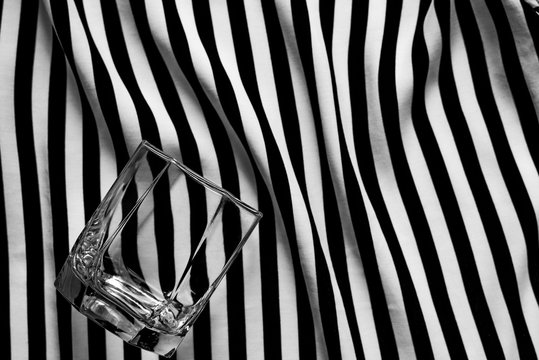 Abstract geometric black and white background with a glass of old fashioned