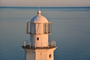 Fototapeta na wymiar Sea lighthouse close-up against the sea and horizon