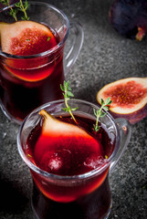Fall and winter red sangria cocktail with thyme and figs, on black stone table, copy space
