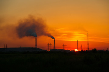 Toxic factory smoke causes harm to the environment at sunset