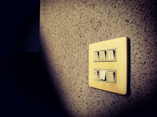 Lamp Switch on wall, under light and shadow.